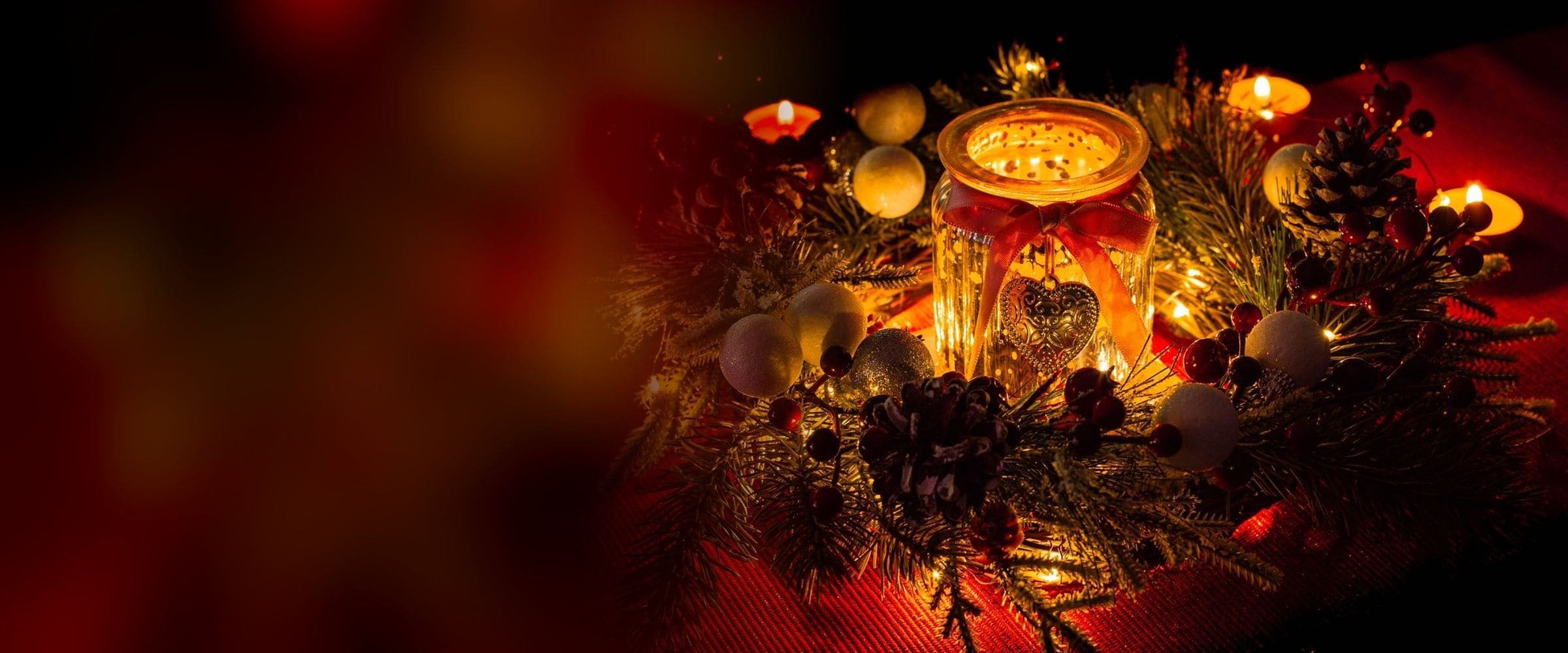 Glowing candle jar centrepiece with pine, berries and fairy lights